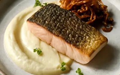 Carp in a modern version: sous-vide with crispy skin, celery puree, and caramelized onion